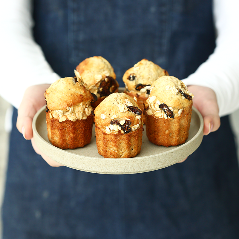 banana and blueberry muffins with oats on a round plate, being held