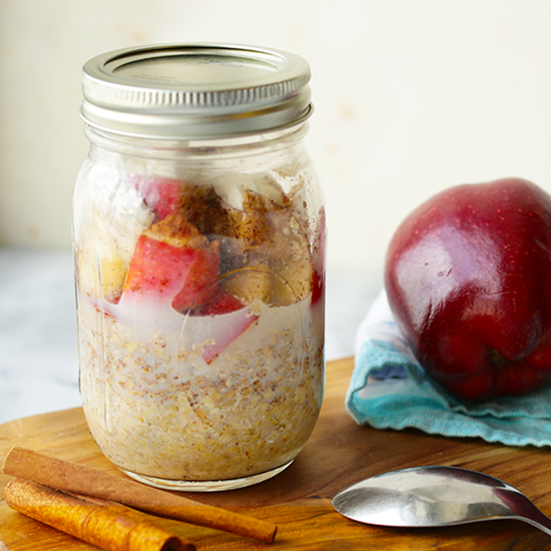 Full jar of apple and cinnamon overnight oats with an apple