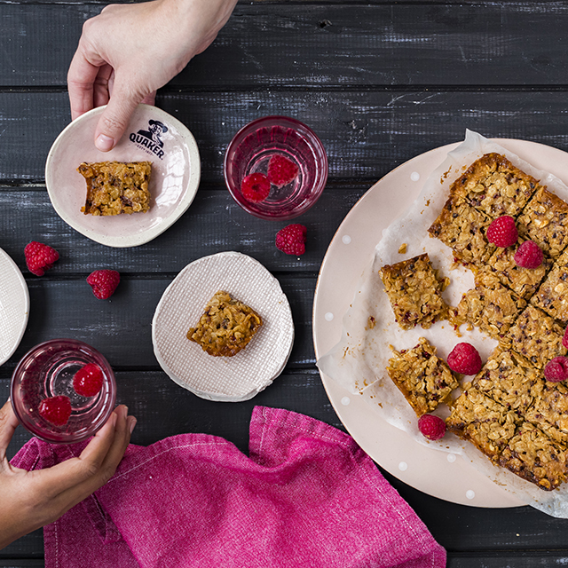 Tasty apricot, raspberry and oat snack bites dished out and topped with fresh raspberries
