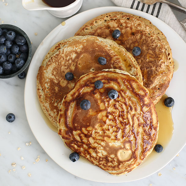 oatmeal pancakes on a plate with blueberries sprinkled on top